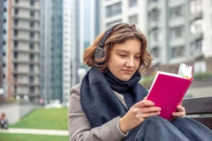 Mujer con libro para estudiar inglés en el exterior