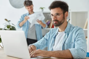 Hombre con computador realizando trabajo de medio tiempo mientras estudias en el exterior