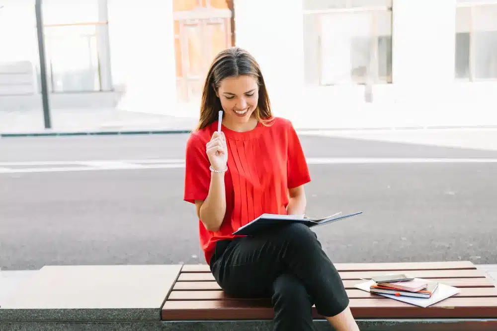 Mujer sentada con cuaderno y lapicero considerando qué estudiar en España