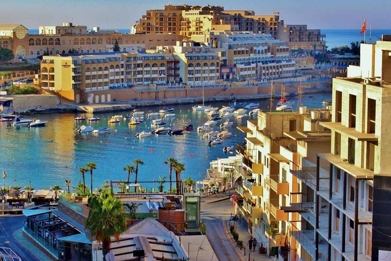 Bahía de Spinola en St Julian's, Malta, con barcos amarrados y hoteles frente al mar